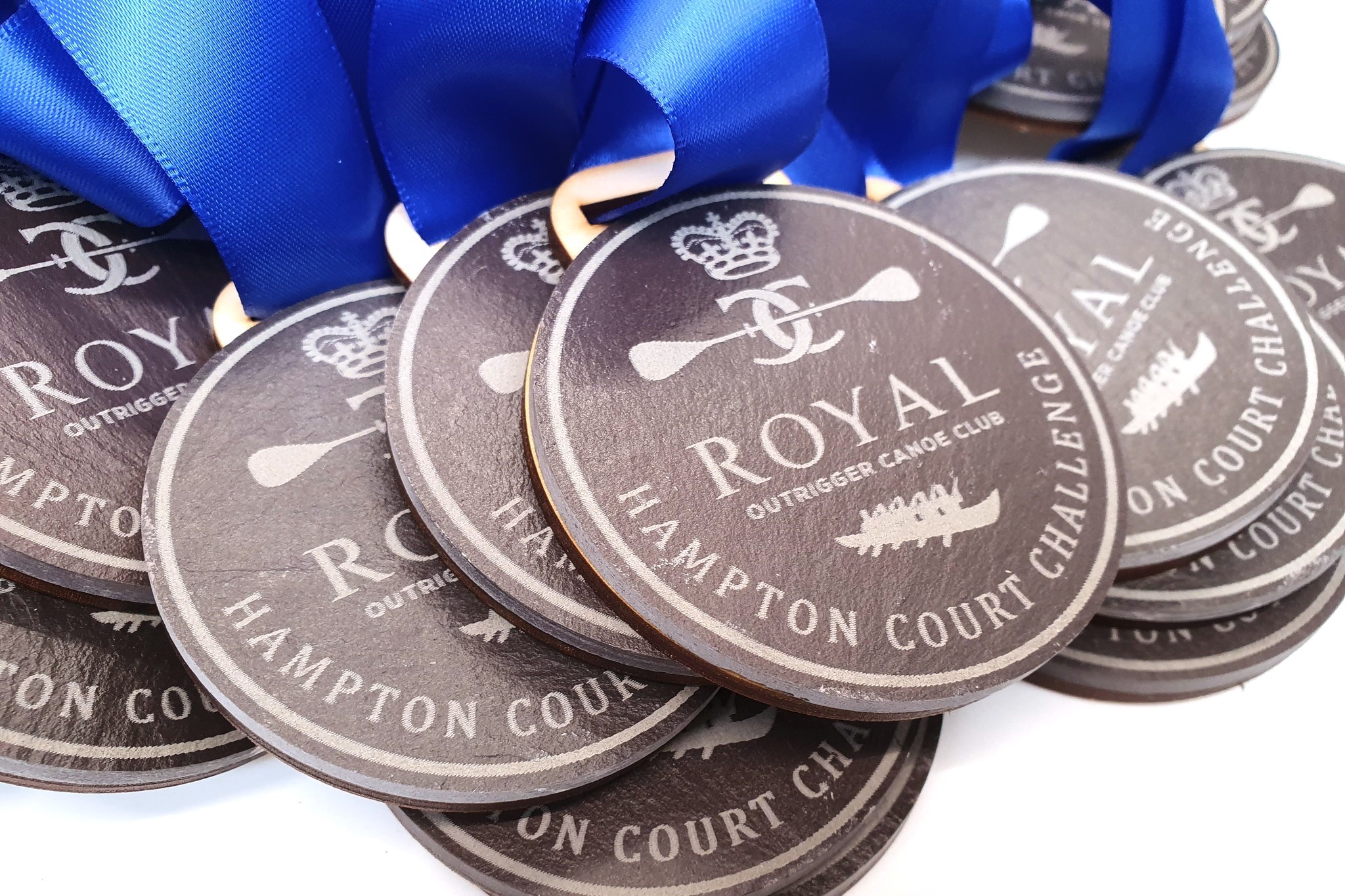 Custom slate and wood 'Royal Outrigger Canoe Club' medals.