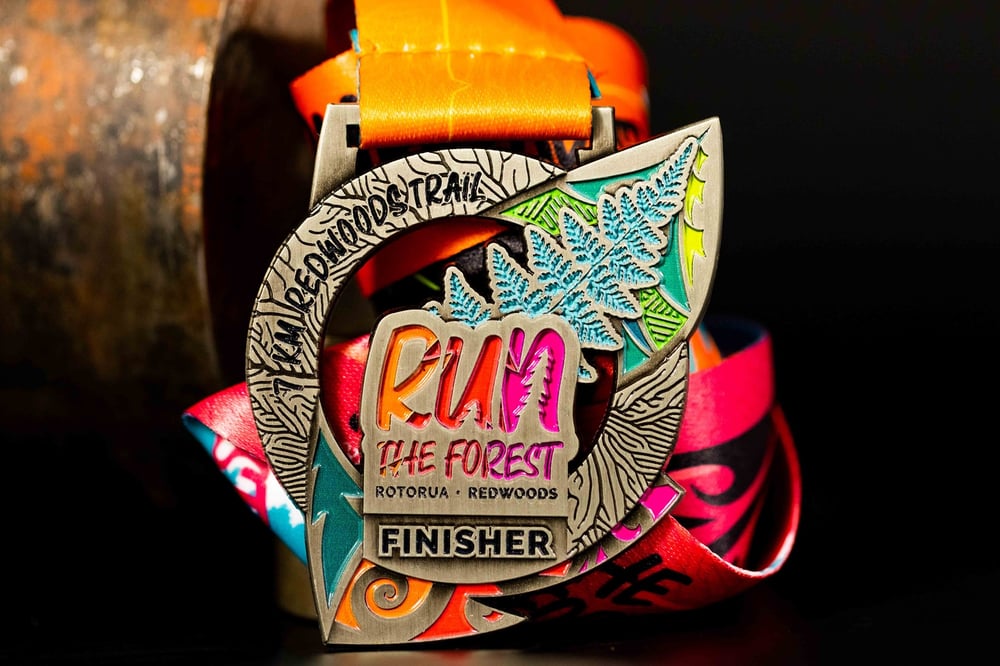 Run The Forest's custom '7km Redwoods Trail Finisher' medal, coloured with enamel.