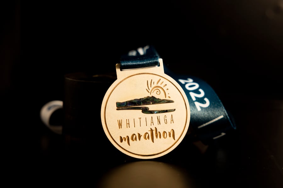 Custom Whitianga Marathon wooden medal with seashell insert.